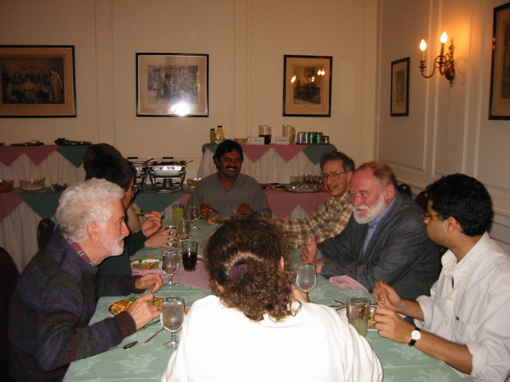 a group sitting around a dinner table conversing