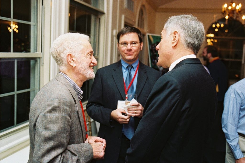 Stephen H. Unger shaking hands with another individual, both are formally dressed