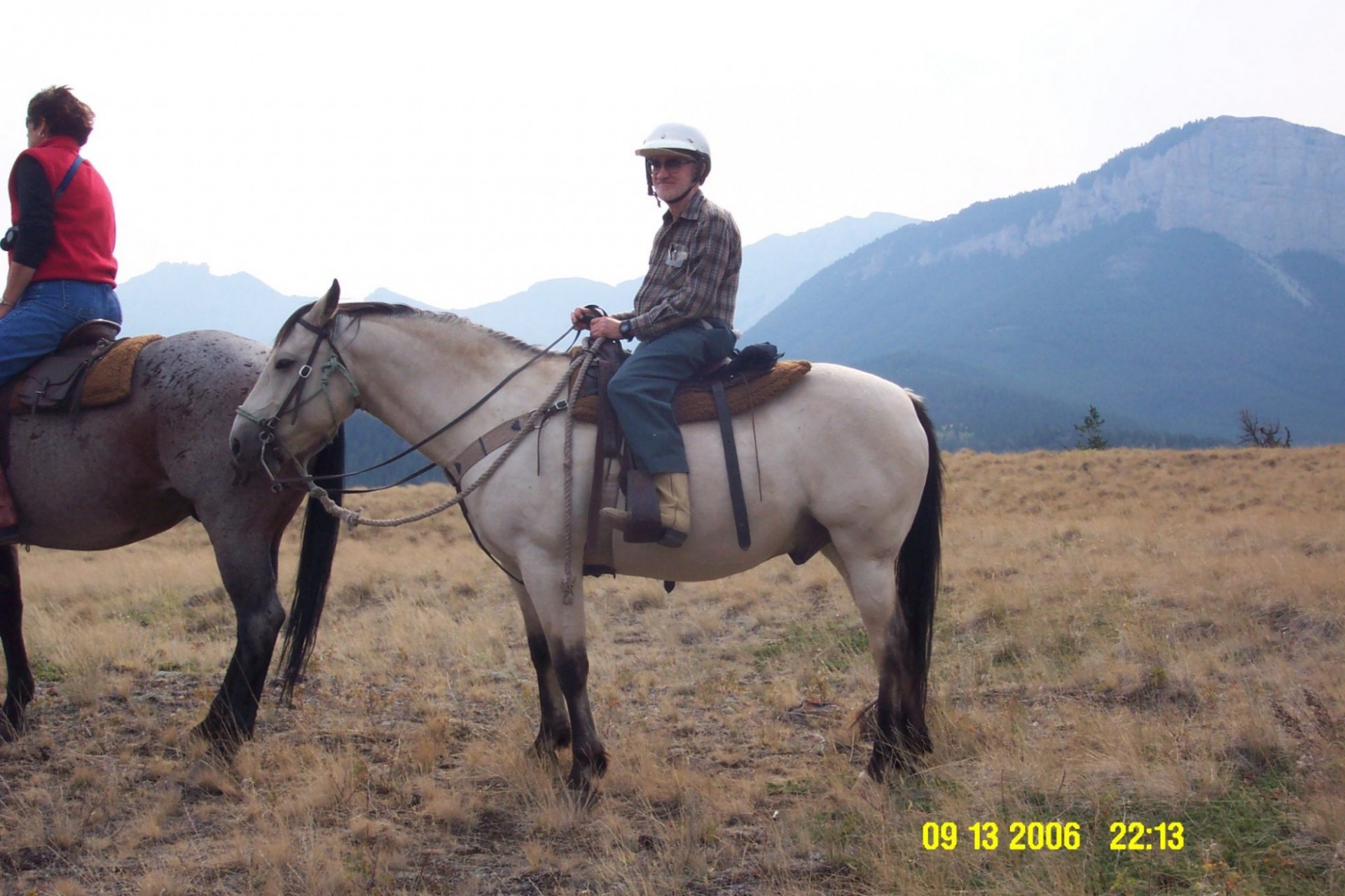 Stephen H. Unger on horseback on a grassy plain, a mountain in the background