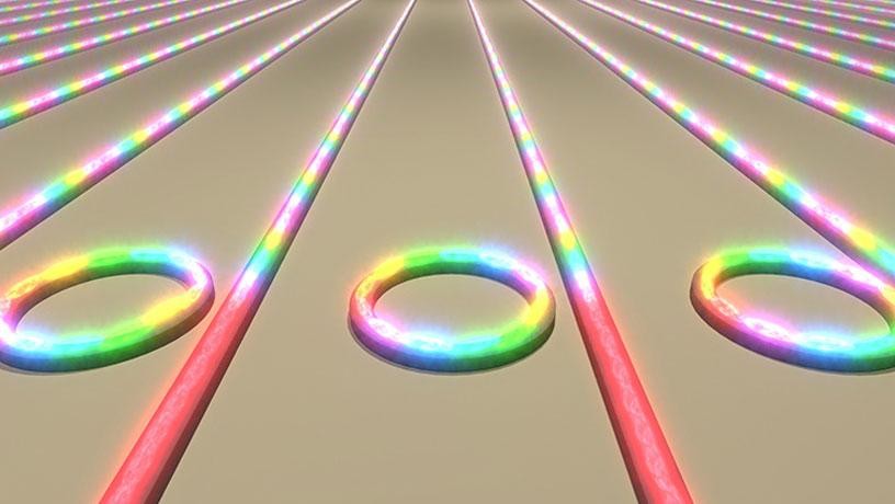 Illustration showing an array of microring resonators on a chip converting laser light into frequency combs.