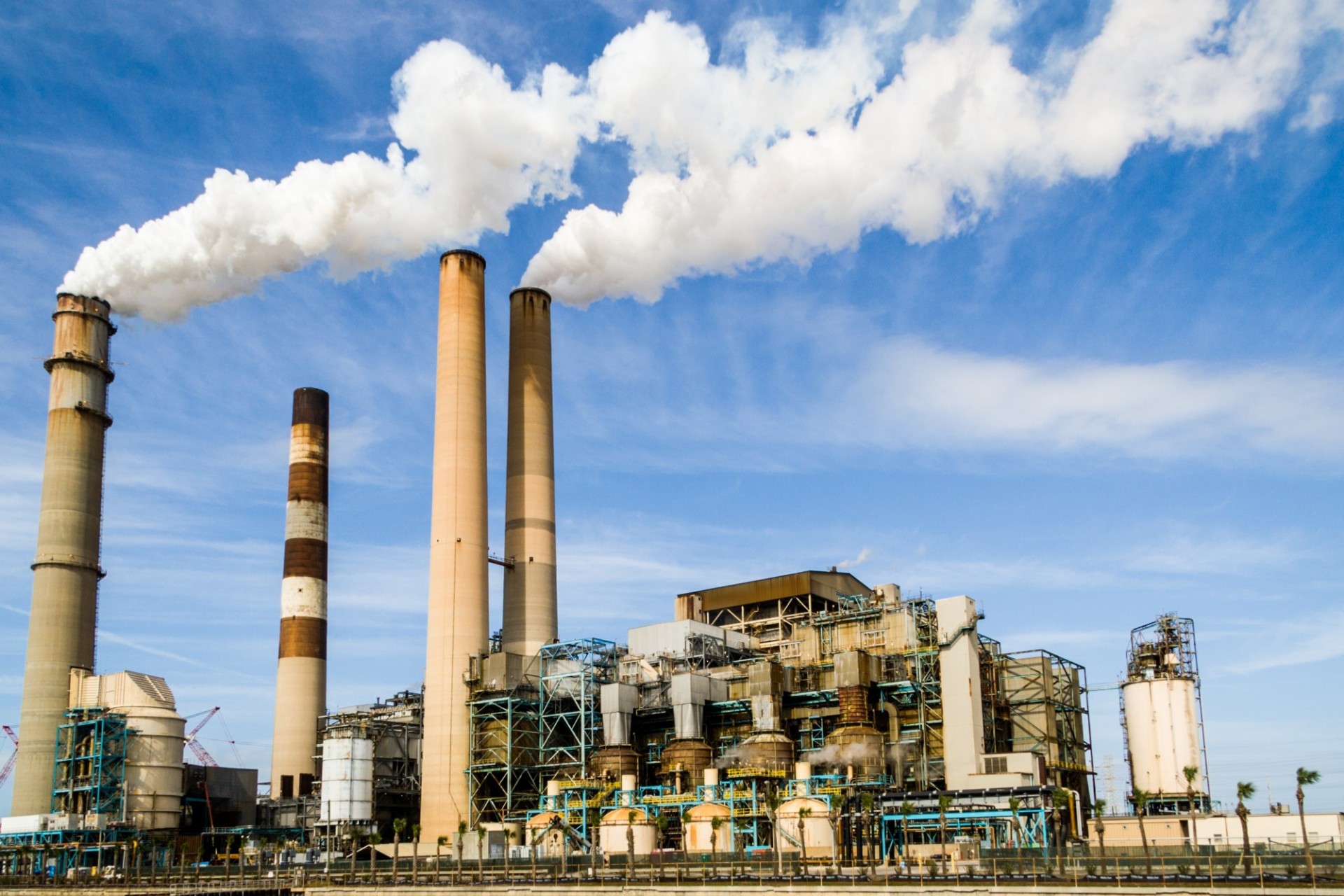 a factory with smoke wafting from the smoke stacks