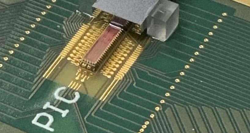 Photonic transmitter chip mounted on a printed circuit board with electrical and fiber optic connections. Credit: Lightwave Research Laboratory/Columbia Engineering