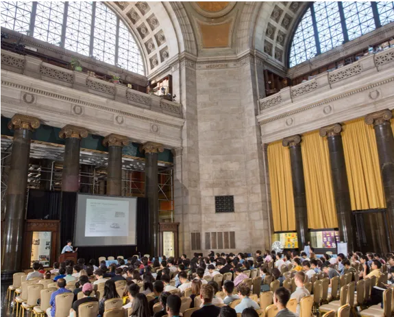 Audience in large hall looking at screen