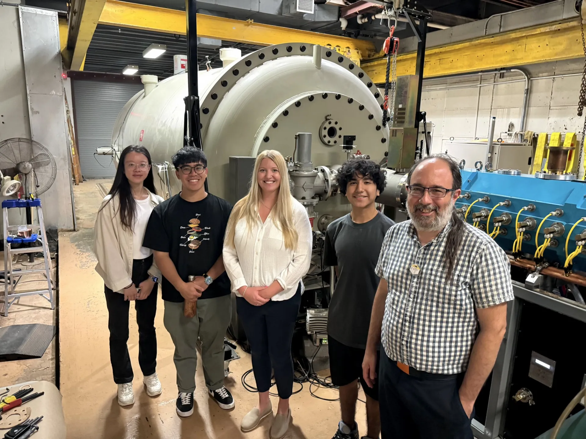 Recent photo from July 2024: ETHER Lab group trip to Columbia's Radiological Research Accelerator Facility (RARAF). Pictured here in front of the primary particle accelerator with RARAF Director Guy Garty (front/far right).